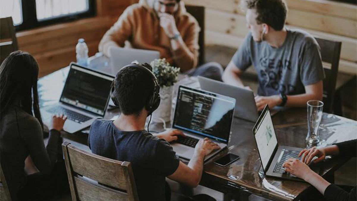 Software engineers talking and typing at a desk